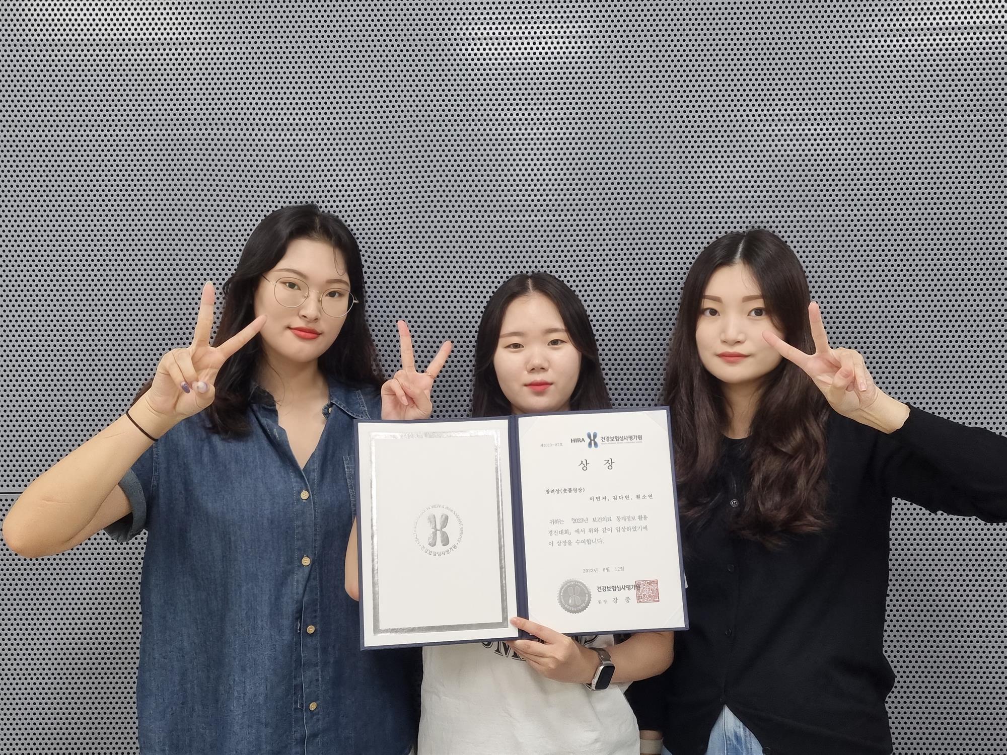 사진설명: 안산대 보건의료정보학과 학생 세명이서 상장을 들고 있다.